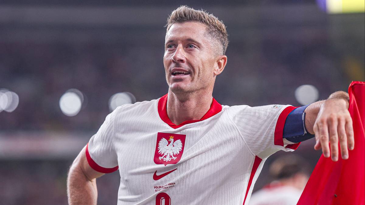 Robert Lewandowski w białej koszulce reprezentacji Polski z godłem na piersi i czerwonymi elementami.