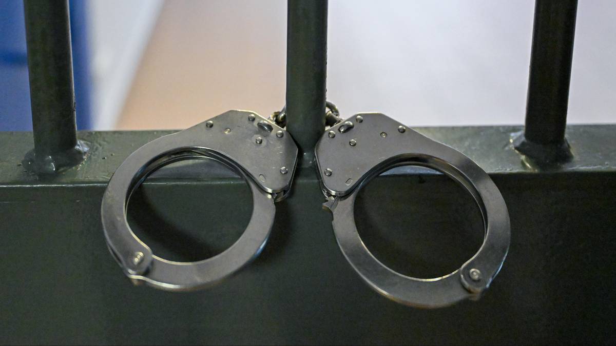 Zaciśnięte kajdanki wiszące na metalowych prętach.