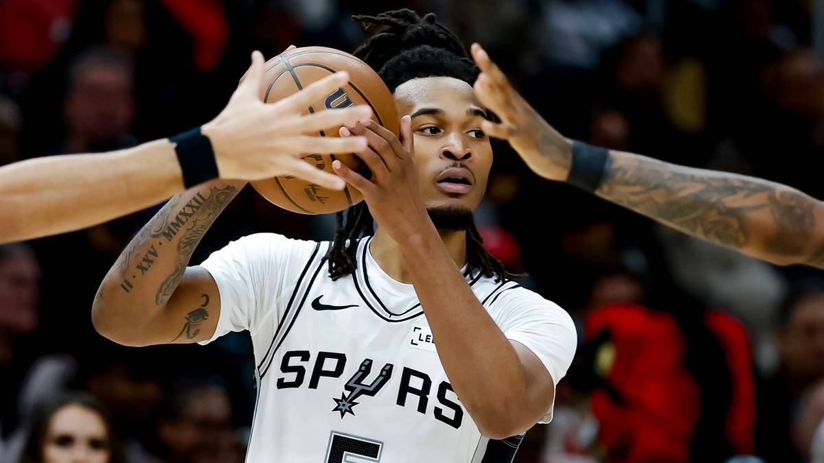 Koszykarz San Antonio Spurs z piłką, otoczony przez obrońc&oacute;w.