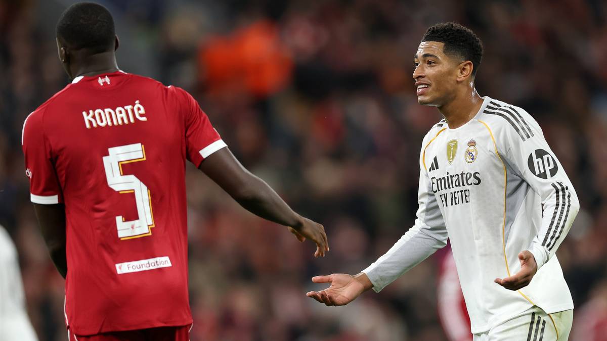 Piłkarz Liverpoolu w czerwonej koszulce z numerem 5 i nazwiskiem Konaté rozmawia z piłkarzem Realu Madryt w białej koszulce.
