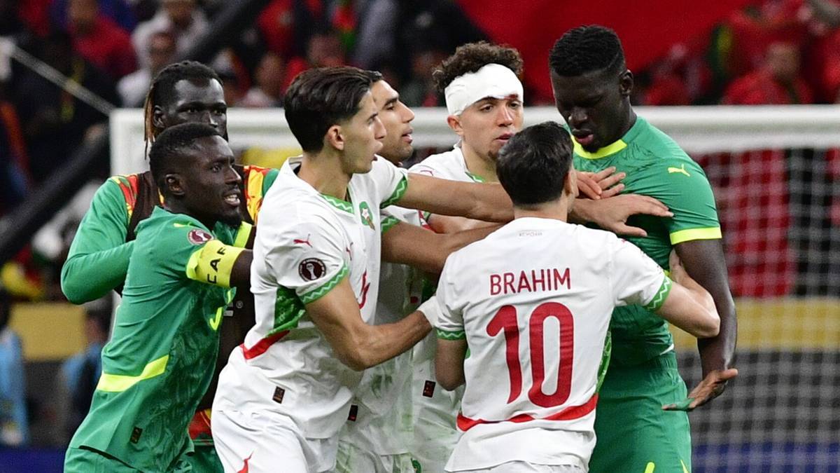 Piłkarze Senegalu i Maroka w środku boiska podczas przepychanki po kontrowersyjnej decyzji sędziego.