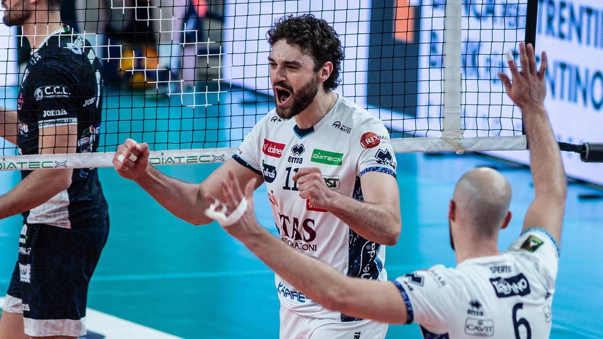 Siatkarz w białej koszulce z numerem 11 świętuje z kolegą z drużyny po zdobyciu punktu lub zwycięstwie w meczu.