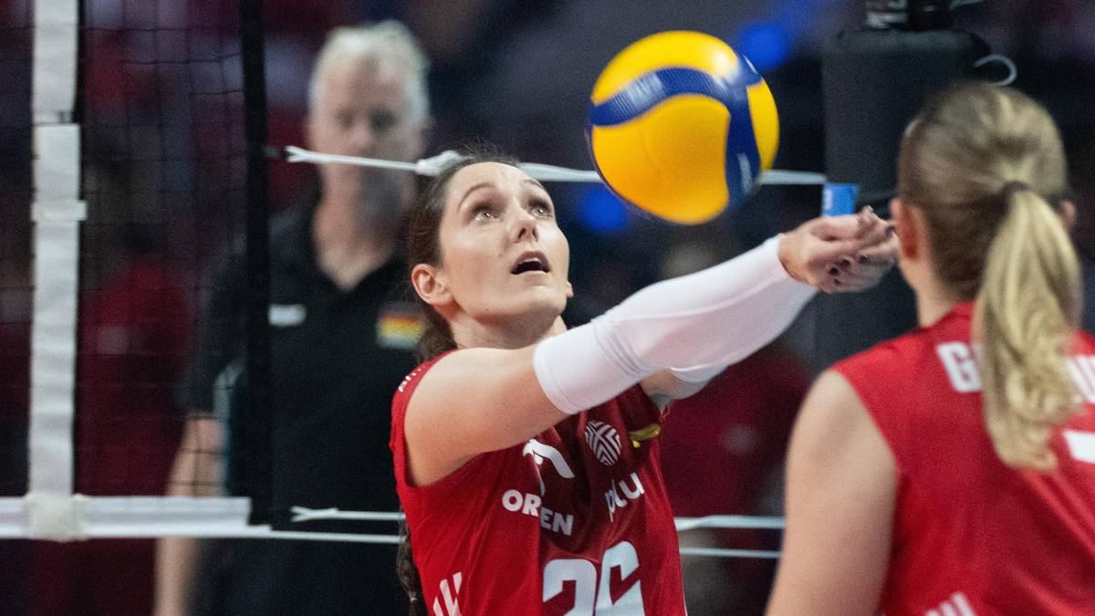 Siatkarka w czerwonej koszulce z numerem 26 wykonuje zagrywkę górnym sposobem.