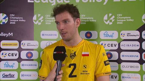 Mężczyzna w ż&oacute;łtej koszulce siatkarskiej, ubrany w str&oacute;j sportowy z polską flagą, udziela wywiadu z mikrofonem.