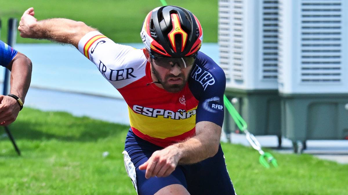 Mężczyzna w kasku i stroju sportowym z napisem "ESPANA" jedzie na rolkach po torze.