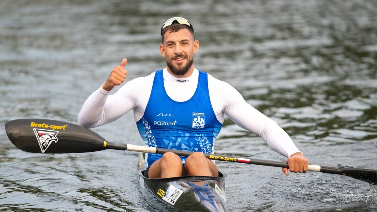 Mężczyzna w kajaku wykonuje gest kciuka w górę.