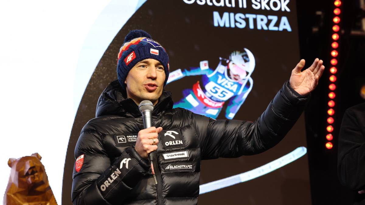 Kamil Stoch przemawia do mikrofonu, w tle grafika z sylwetką skoczka narciarskiego i napisem "Ostatni skok MISTRZA".