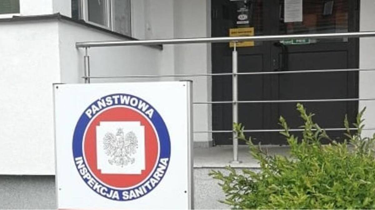 Znak Państwowej Inspekcji Sanitarnej przed budynkiem.