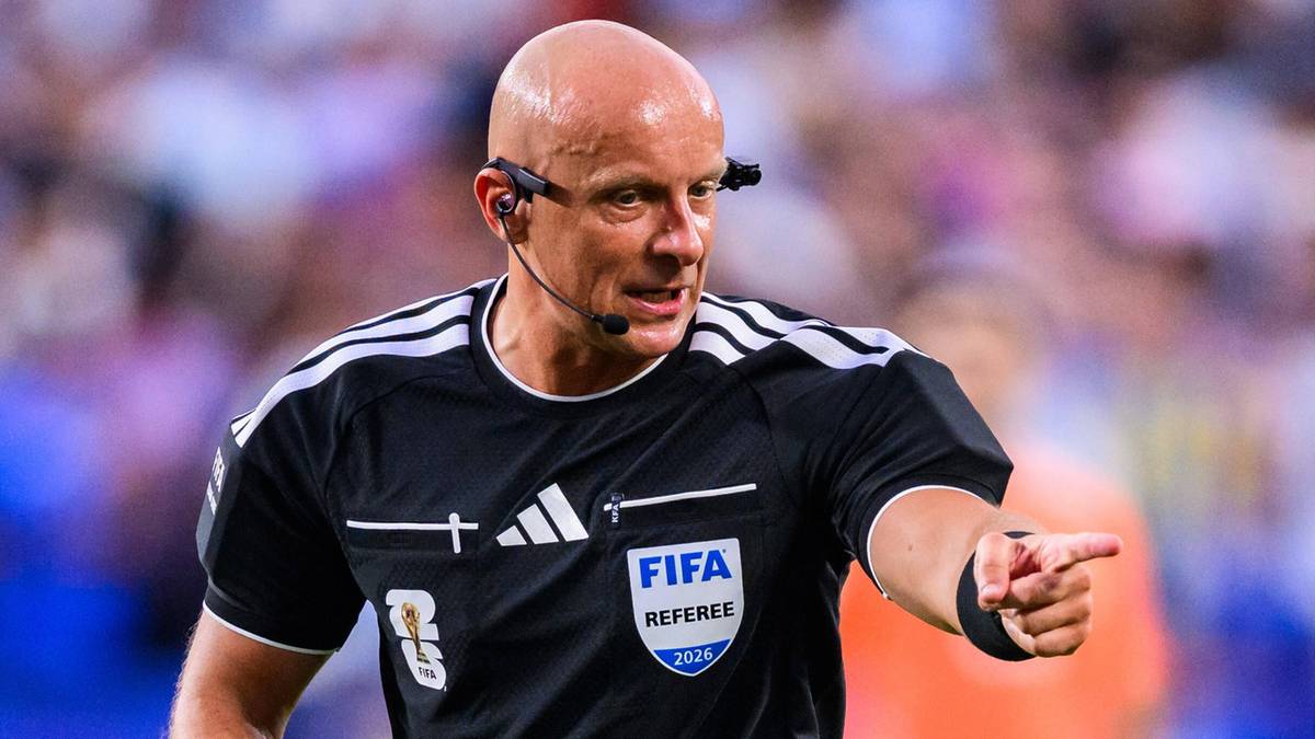 Sędzia piłkarski Szymon Marciniak w czarnym stroju sportowym na boisku
