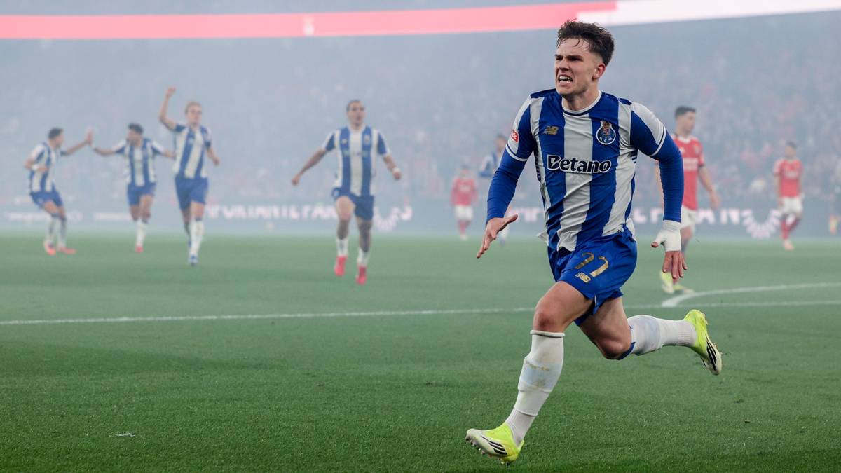 Piłkarz FC Porto w niebiesko-białym stroju biegnie po zielonej murawie stadionu.