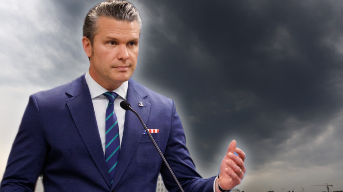 Mężczyzna w garniturze przemawia przy m&oacute;wnicy.