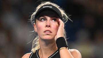 Portret kobiety, tenisistki, w czarnej czapce z daszkiem "Reebok", z opaską na czole i w stroju sportowym.