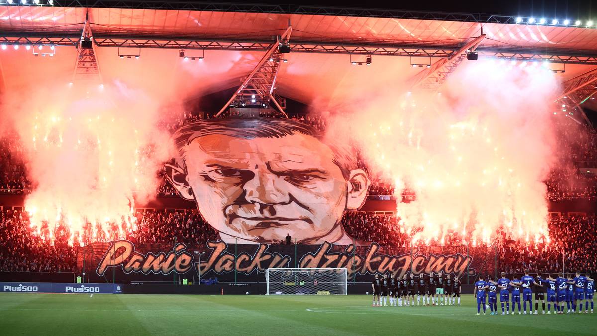 Transparent z wizerunkiem Jacka Magiera i napisem "Panie Jacku, dziękujemy" na tle stadionu z pirotechniką.