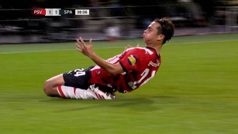 Piłkarz w czerwono-białej koszulce ślizga się na murawie po strzeleniu bramki, celebrując sukces w meczu PSV Eindhoven ze Spartą Rotterdam.