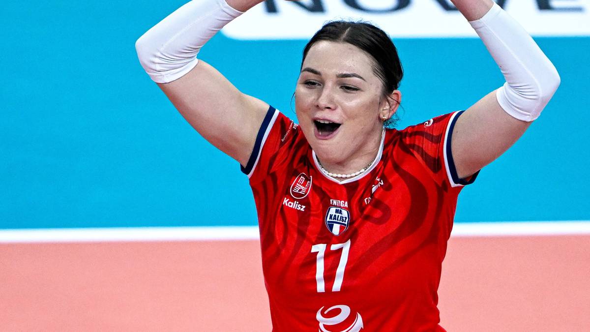 Dwie siatkarki w czerwonych strojach świętują na boisku.