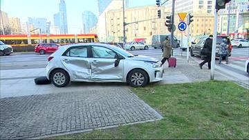 Uszkodzony samoch&oacute;d osobowy leżący na boku na chodniku w centrum Warszawy, z widocznymi wgnieceniami po lewej stronie.