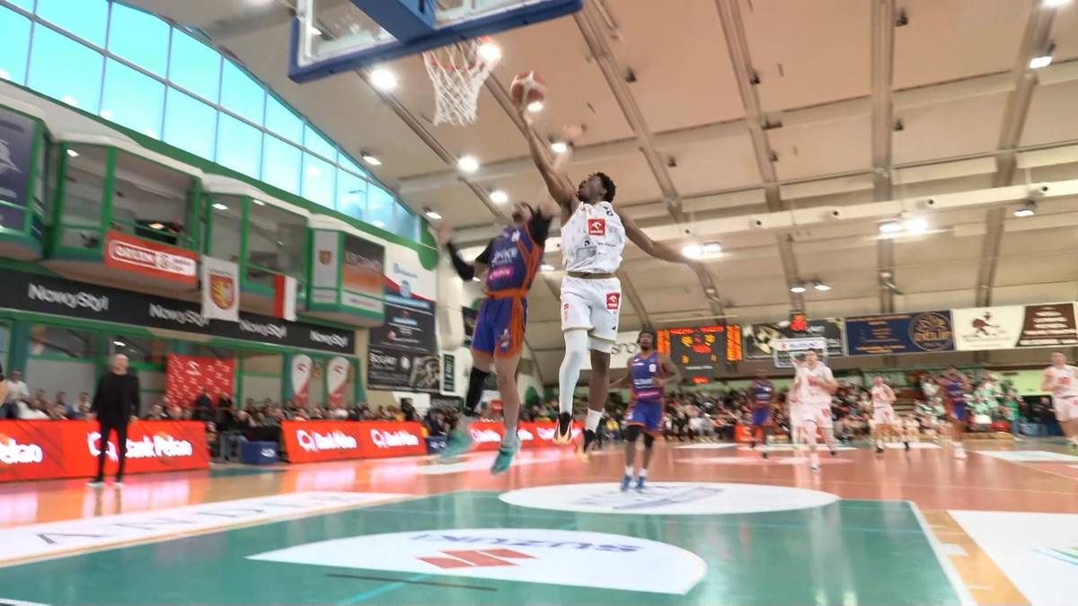 Dw&oacute;ch zawodnik&oacute;w koszyk&oacute;wki walczących o piłkę w powietrzu pod koszem.