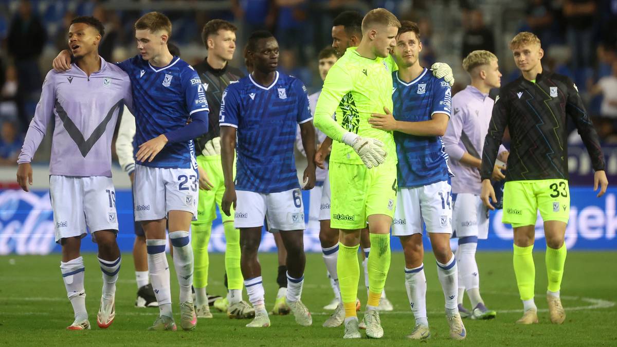 Drużyna piłkarska Lecha Poznań w komplecie strojów, patrząca w stronę kamery po wygranym meczu.