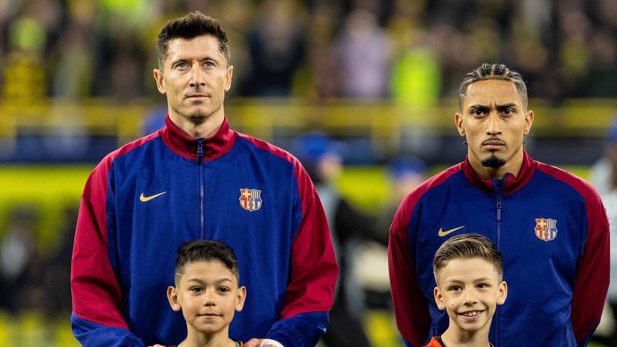 Dw&oacute;ch mężczyzn w strojach piłkarskich FC Barcelona, z dziećmi obok.