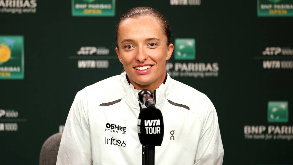 Iga Świątek siedząca przy stole konferencyjnym z mikrofonem, podczas turnieju Indian Wells.