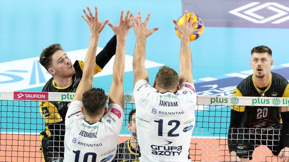 Siatkarze drużyny PGE GiEK Skra Bełchatów bronią pola podczas meczu, blokując atak przeciwnika.