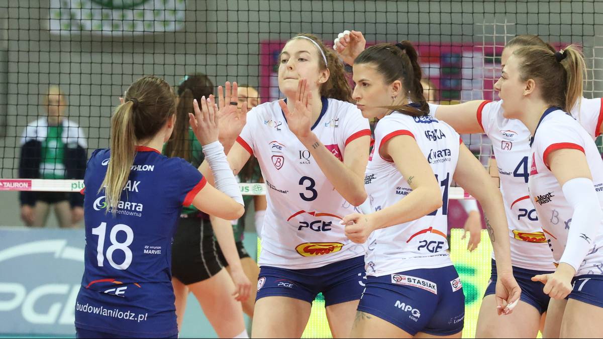 Siatkarki PGE Budowlanych Ł&oacute;dź w białych strojach świętują zdobyty punkt, jedna z nich podnosi rękę w geście radości.