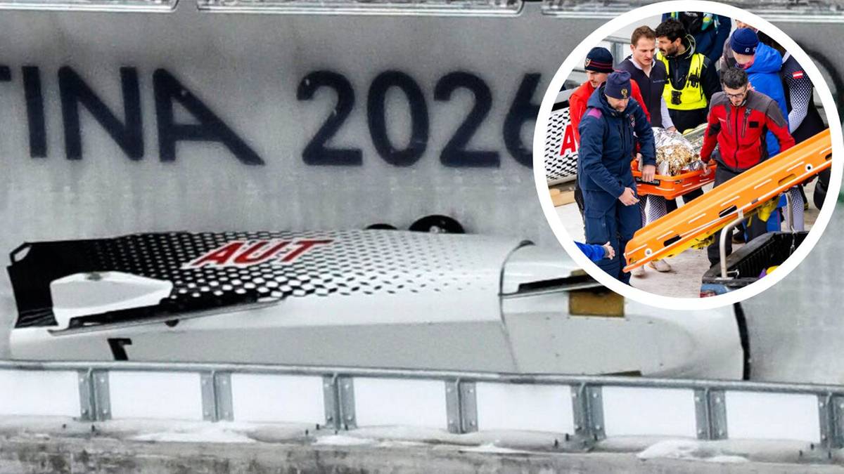 Biały dwuosobowy bobslej z czarnym wzorem i napisem "AUT" w pozycji do zjazdu. Obok, w okręgu, grupa mężczyzn w kurtkach zimowych niesie nosze z osobą.