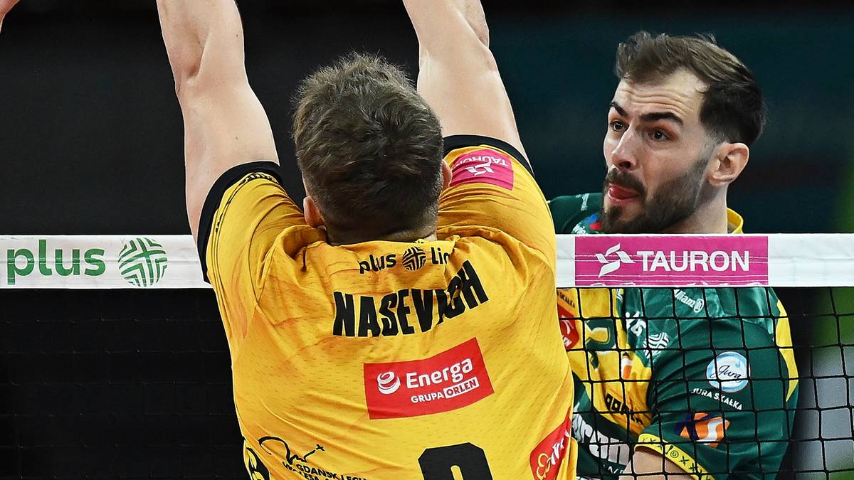 Siatkarz wykonujący zagrywkę podczas meczu siatkówki.