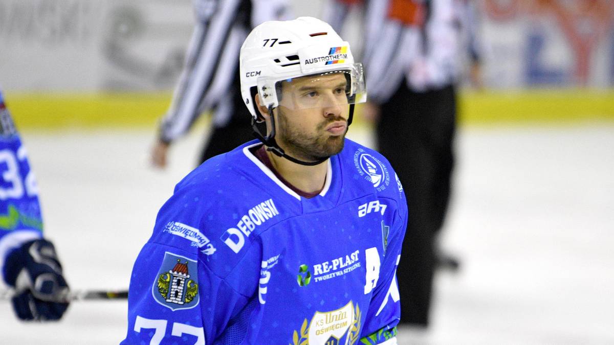 Hokeista w niebieskim stroju z numerem 77 na koszulce, patrzący w bok.