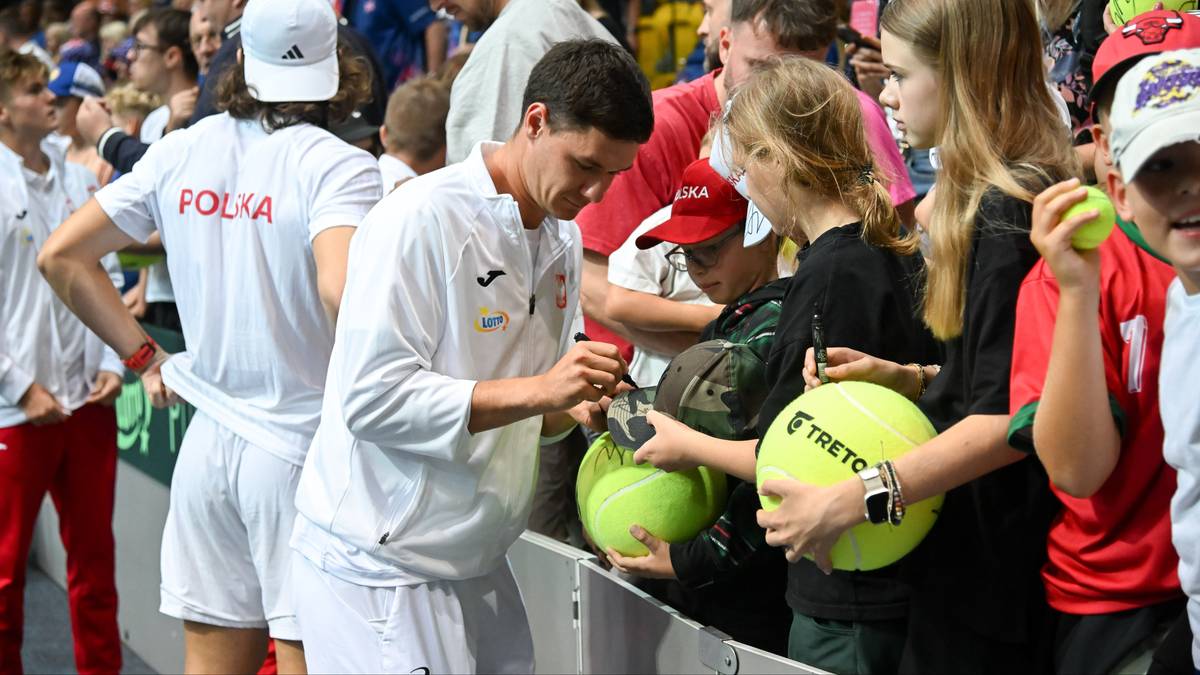 Kamil Majchrzak, polski tenisista, podpisuje piłkę tenisową grupie młodych fanów.