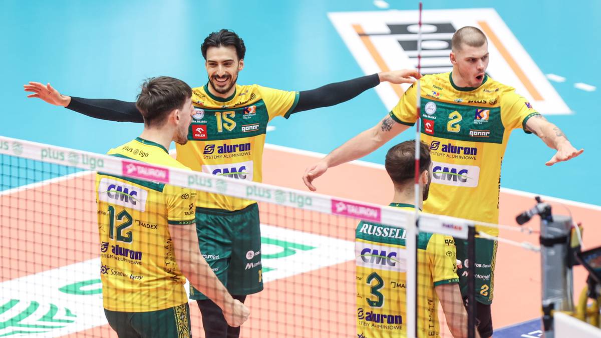 Czterech siatkarzy w żółto-zielonych strojach celebracji, jeden z nich podnosi ręce w geście zwycięstwa.