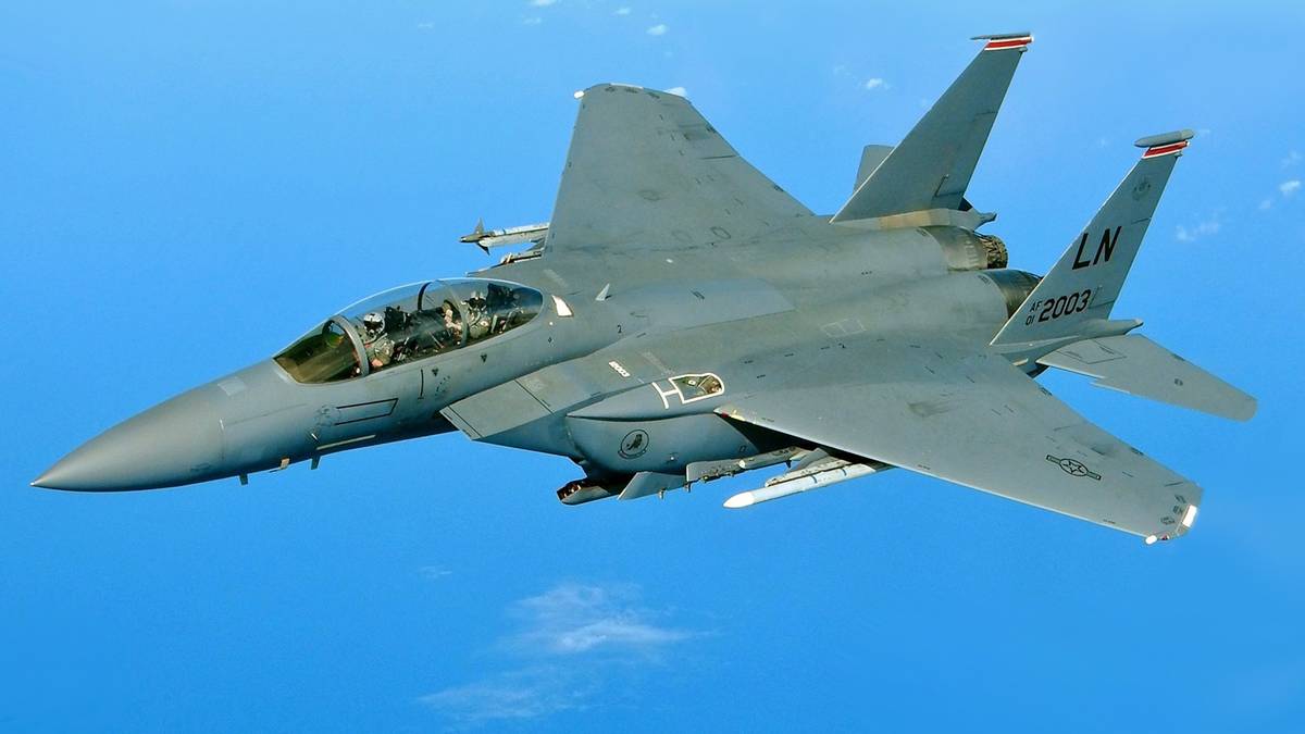 Samolot wojskowy F-15 leci na tle błękitnego nieba.