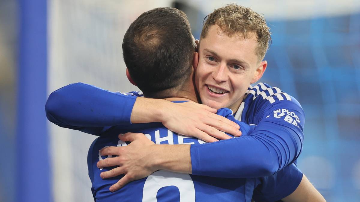 Dwóch piłkarzy Wisły Płock w niebieskich strojach sportowych obejmuje się, okazując radość po meczu.