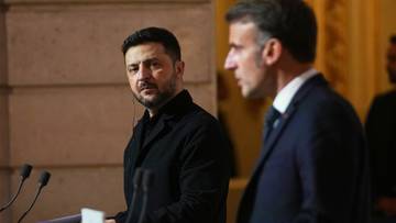 Wołodymyr Zełenski i Emmanuel Macron stoją przy podium podczas spotkania.