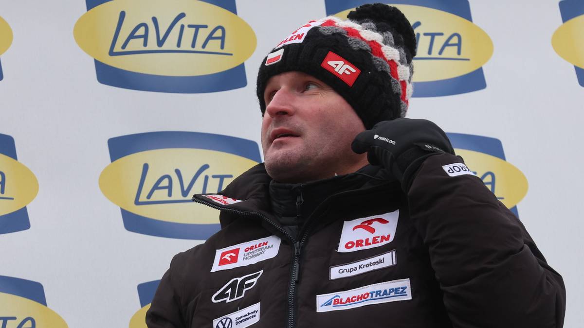 Mężczyzna w zimowej czapce i kurtce sportowej z naszywkami.