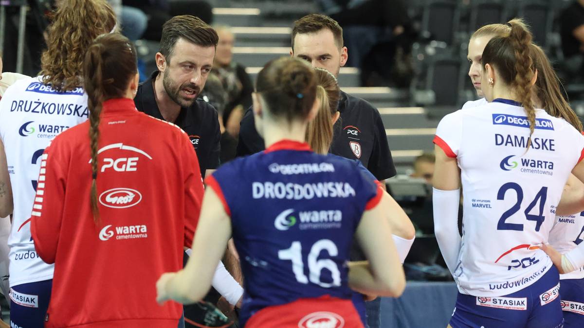 Grupa siatkarek i trenerów omawiających strategię podczas meczu siatkówki.