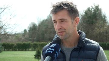 Portret mężczyzny udzielającego wywiadu, z mikrofonem Polsat Sport przed ustami.