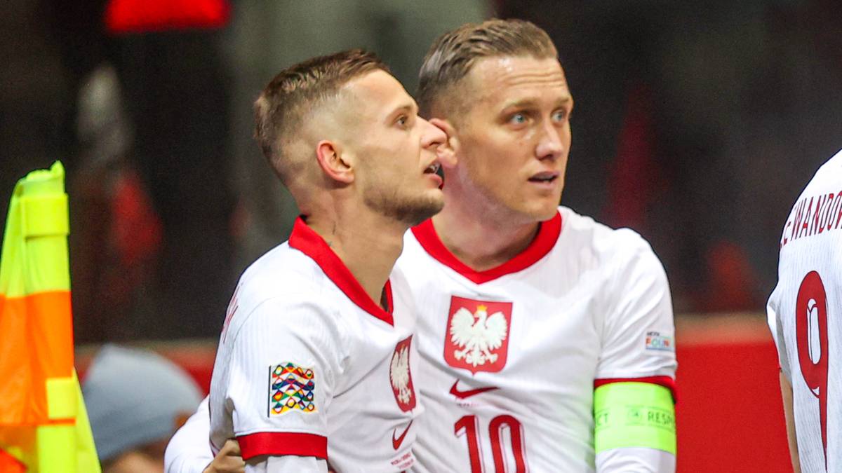 Piłkarze reprezentacji Polski w białych strojach z orzełkiem na piersi.