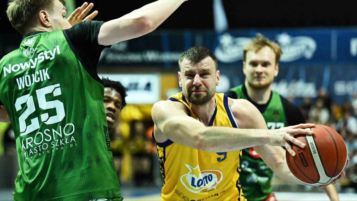 Dw&oacute;ch zawodnik&oacute;w drużyny koszykarskiej w akcji podczas meczu. Jeden z nich, numer 25, zasłania twarz dłonią, drugi, w ż&oacute;łtej koszulce, trzyma piłkę.