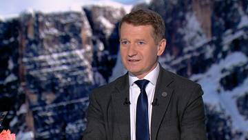 Portret Ireneusza Rasia, mężczyzny w garniturze i krawacie, na tle zaśnieżonych gór.