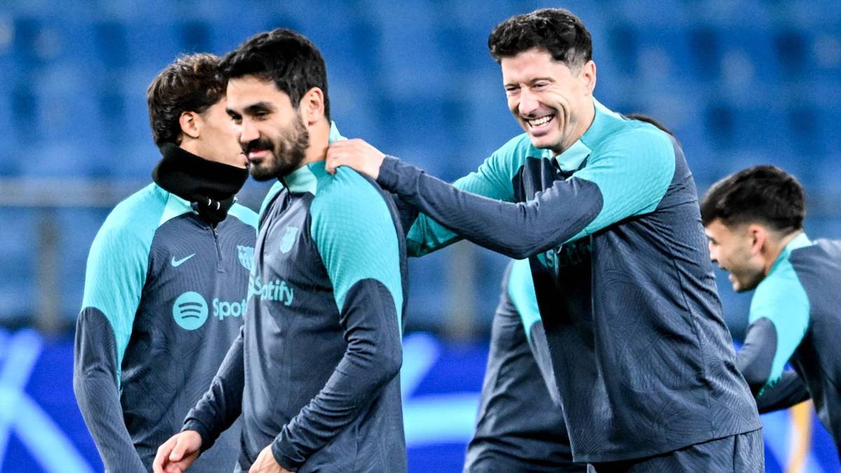 Dwóch piłkarzy w niebiesko-turkusowych strojach, jeden z nich klaszcze drugiego w ramię.