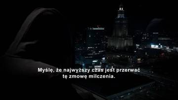 Sylwetka osoby w kapturze na tle nocnej panoramy miasta z widocznym wieżowcem.