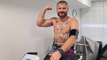 Jan Błachowicz podczas badań geriatrycznych z podłączonym EKG i mankietem ciśnieniowym.