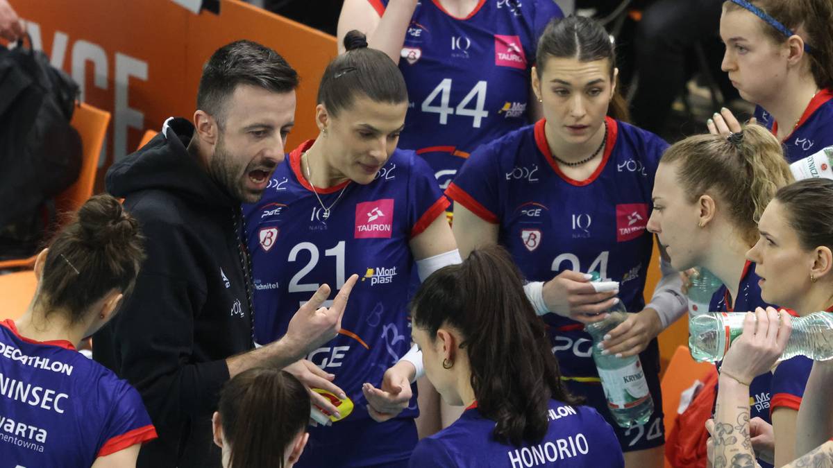 Trener drużyny siatkarskiej ŁKS Commercecon łódź rozmawia z zawodniczkami podczas przerwy w meczu.