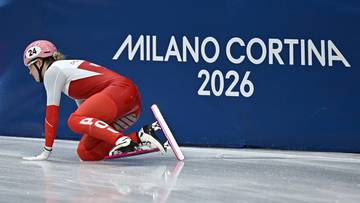 Zawodniczka short tracku Natalia Maliszewska klęczy na lodzie po upadku obok leżącej łyżwy, z napisem "MILANO CORTINA 2026" w tle.