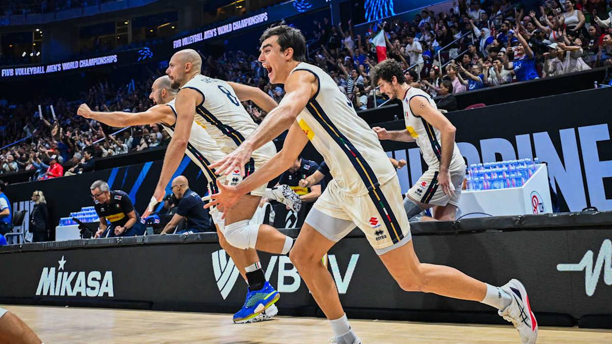 Siatkarze w biało-czarnych strojach z podniesionymi rękami świętują zwycięstwo podczas meczu na stadionie.