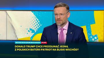 Mężczyzna w garniturze i okularach, na tle ekranu z informacją o możliwym przesunięciu polskiej baterii Patriot na Bliski Wsch&oacute;d.