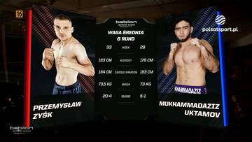 Dw&oacute;ch zawodnik&oacute;w sport&oacute;w walki, Przemysław Zyśk po lewej i Mukhammadaziz Uktamov po prawej, stoi naprzeciwko siebie. Pomiędzy nimi znajduje się ekran z informacjami o wadze, rundach i statystykach obu zawodnik&oacute;w. Obaj zawodnicy są w pozycji bojowej, gotowi do walki.