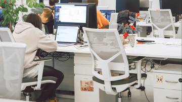 Nowoczesne biuro z pracownikami przy komputerach.