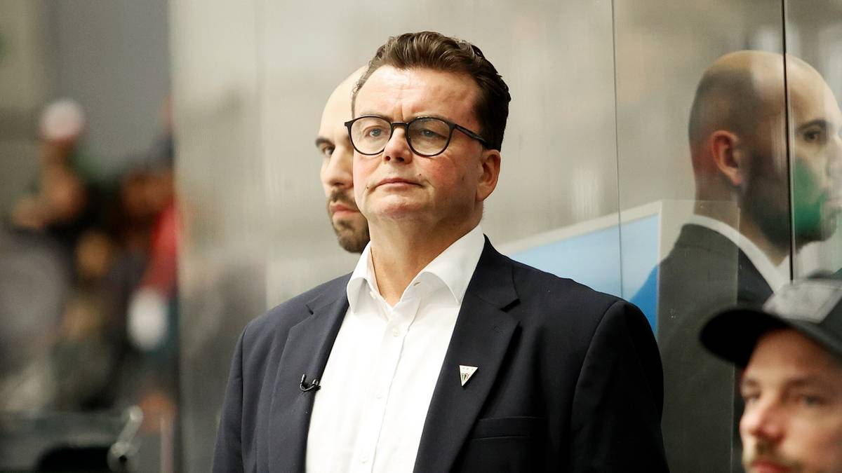 Mężczyzna w okularach i ciemnej marynarce, patrzący przed siebie z poważnym wyrazem twarzy.